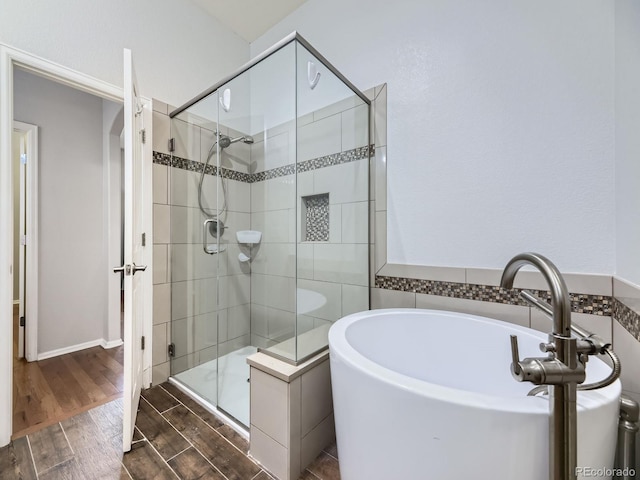 581 N Flat Rock Cir, Aurora, CO 80018 - bathroom with a bath, wood finished floors, and a shower stall