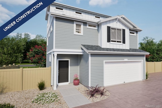 view of front of home with decorative driveway, fence, board and batten siding, and an attached garage