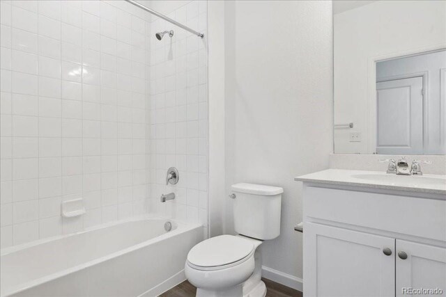 6902 Huddersfield Ln, Castle Pines, CO 80108 - full bathroom featuring vanity, toilet, washtub / shower combination, wood finished floors, and baseboards