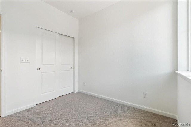 6902 Huddersfield Ln, Castle Pines, CO 80108 - unfurnished bedroom featuring light colored carpet, baseboards, and a closet