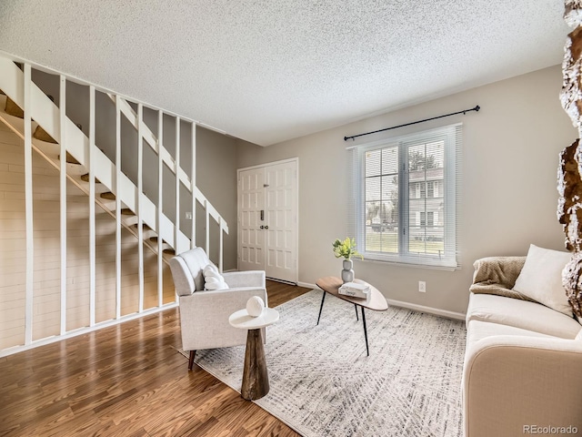 1932 S Oswego Way, Aurora, CO 80014 - living area with wood finished floors, a textured ceiling, stairs, and baseboards