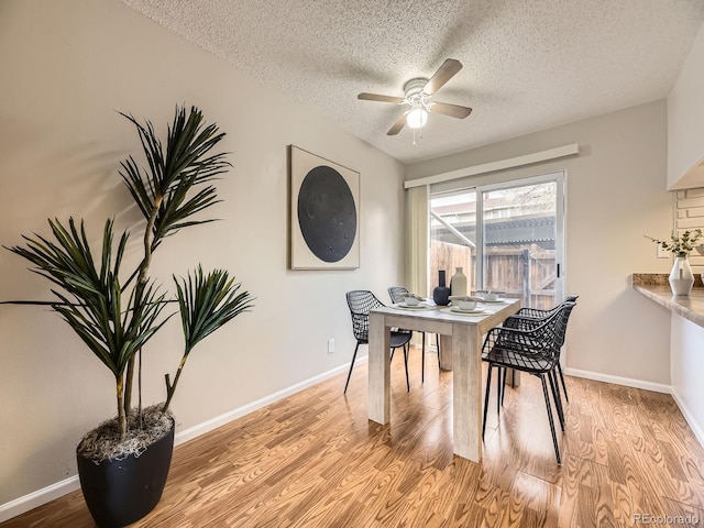 1932 S Oswego Way, Aurora, CO 80014 - dining area with a textured ceiling, a ceiling fan, light wood finished floors, and baseboards