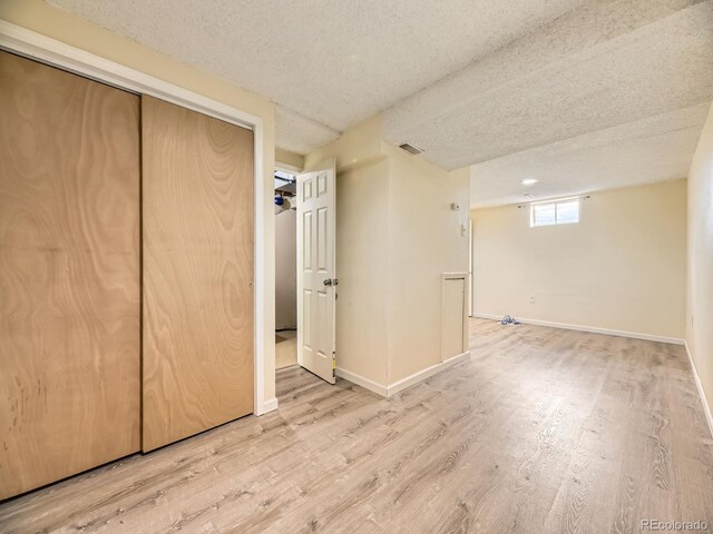 1932 S Oswego Way, Aurora, CO 80014 - unfurnished bedroom featuring wood finished floors, baseboards, a textured ceiling, and a closet