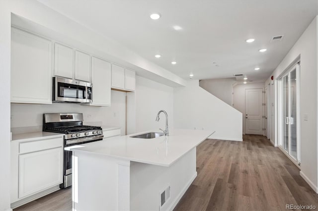1368 Penner Dr, Erie, CO 80026 - kitchen with stainless steel appliances, a sink, recessed lighting, white cabinets, and light wood-style flooring