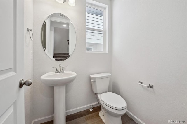 1368 Penner Dr, Erie, CO 80026 - bathroom featuring wood finished floors, toilet, baseboards, and a sink