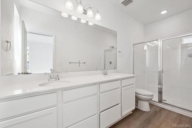 1368 Penner Dr, Erie, CO 80026 - full bathroom featuring a stall shower, wood finished floors, toilet, and double vanity