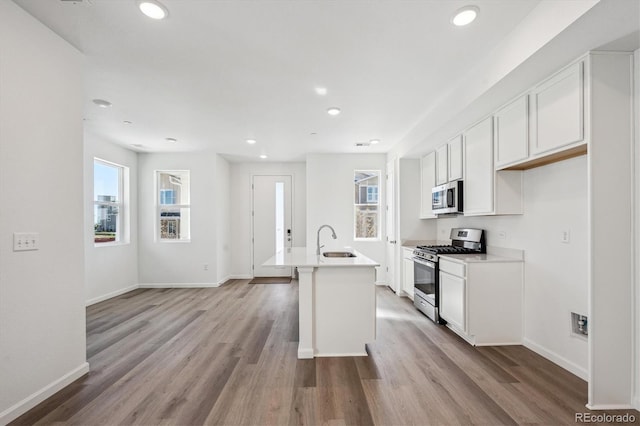 1368 Penner Dr, Erie, CO 80026 - kitchen featuring appliances with stainless steel finishes, healthy amount of natural light, light wood-style floors, recessed lighting, and white cabinets