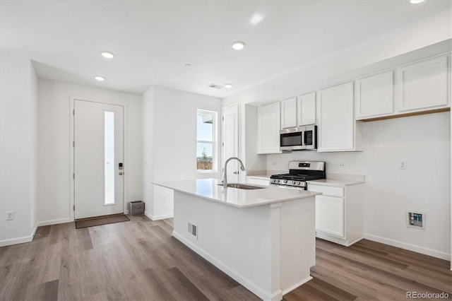 1368 Penner Dr, Erie, CO 80026 - kitchen with stainless steel appliances, a sink, recessed lighting, wood finished floors, and white cabinets
