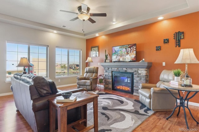 living area with wood finished floors, ceiling fan, recessed lighting, baseboards, and a fireplace