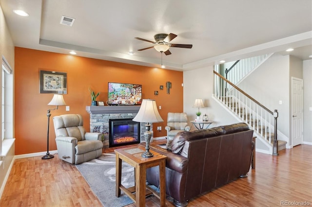 living area with light wood finished floors, baseboards, ceiling fan, stairway, and recessed lighting