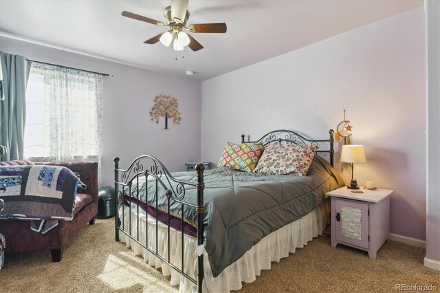 carpeted bedroom with ceiling fan and baseboards