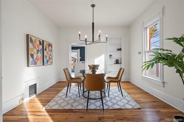 dining room featuring wood-type flooring and a notable chandelier