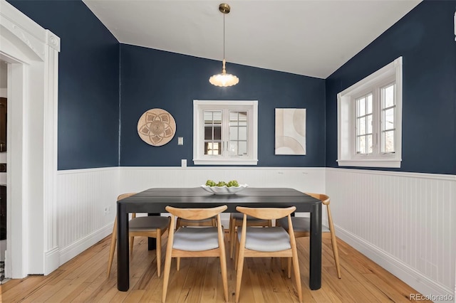 dining room featuring vaulted ceiling, light hardwood / wood-style floors, and breakfast area