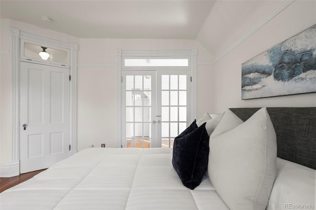 bedroom featuring hardwood / wood-style flooring, lofted ceiling, and french doors