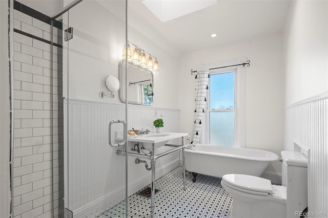 bathroom featuring a skylight, toilet, and separate shower and tub