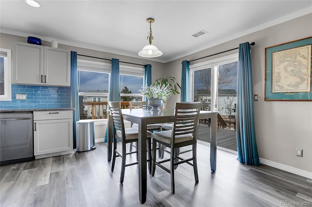 dining area with crown molding and hardwood / wood-style floors