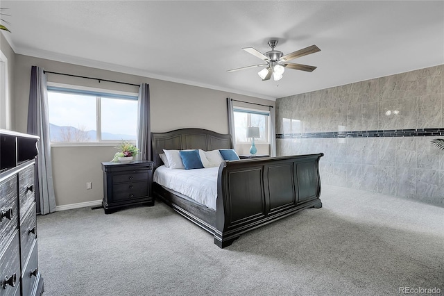 carpeted bedroom featuring crown molding, ceiling fan, and tile walls