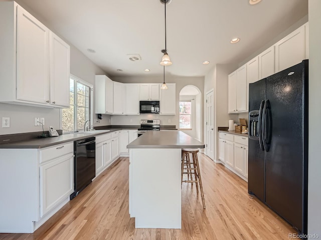 kitchen with black appliances, white cabinetry, and plenty of natural light