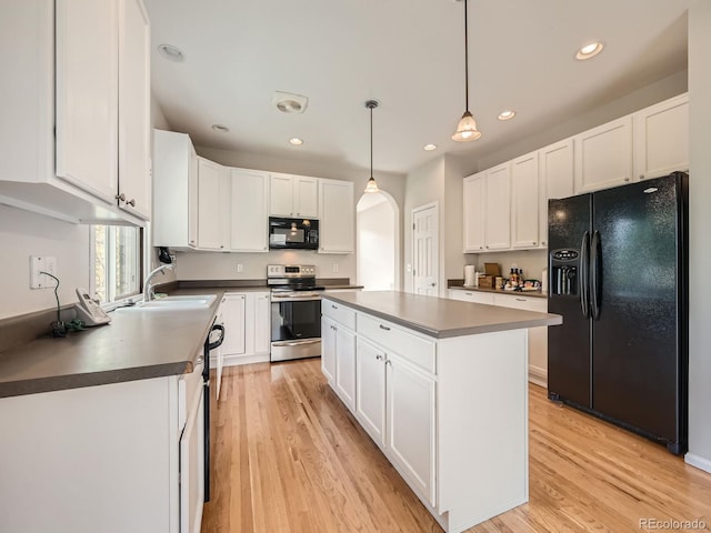 kitchen featuring white cabinetry, black appliances, sink, and decorative light fixtures