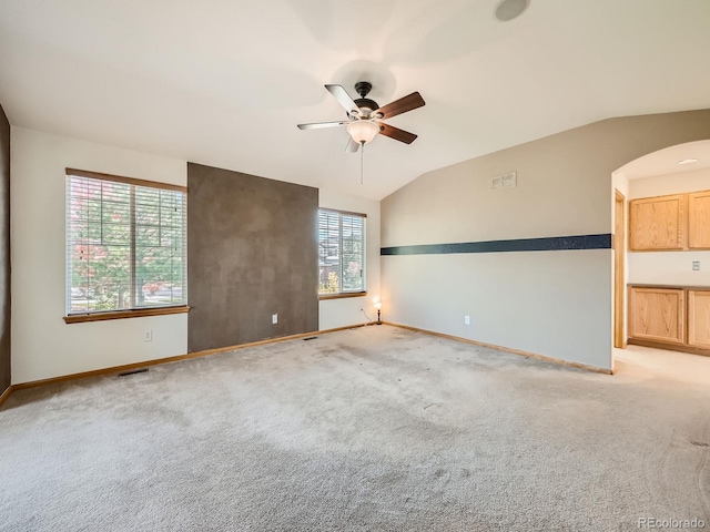 unfurnished room featuring ceiling fan, plenty of natural light, and vaulted ceiling