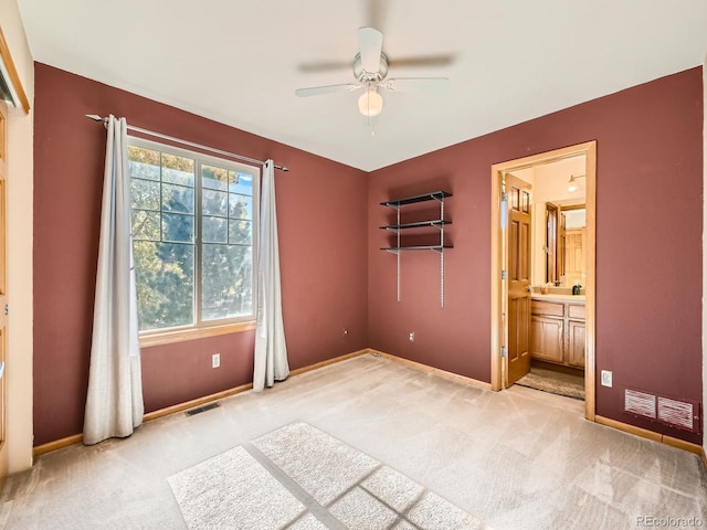 unfurnished bedroom featuring connected bathroom, ceiling fan, and light colored carpet