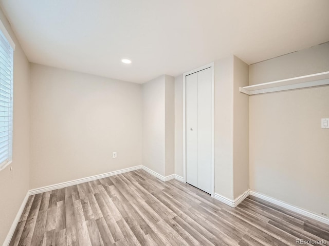 unfurnished bedroom featuring light hardwood / wood-style flooring and a closet