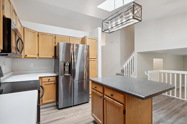 kitchen with stainless steel fridge with ice dispenser, light wood-type flooring, a center island, and range