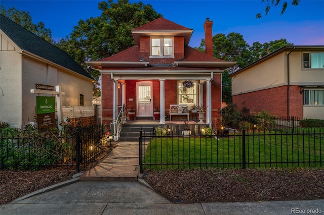 3016 N Franklin St, Denver, CO 80205 - view of front of home featuring covered porch, brick siding, a chimney, a fenced front yard, and a shingled roof