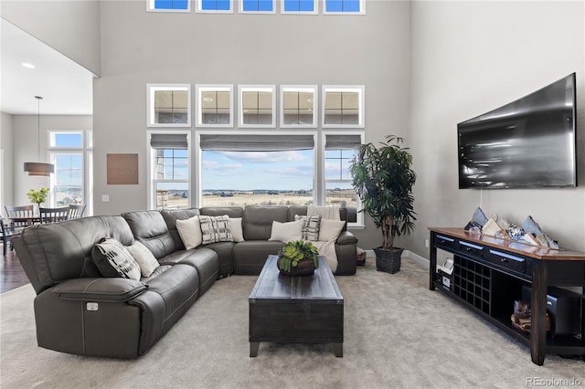 living room featuring light carpet and a high ceiling