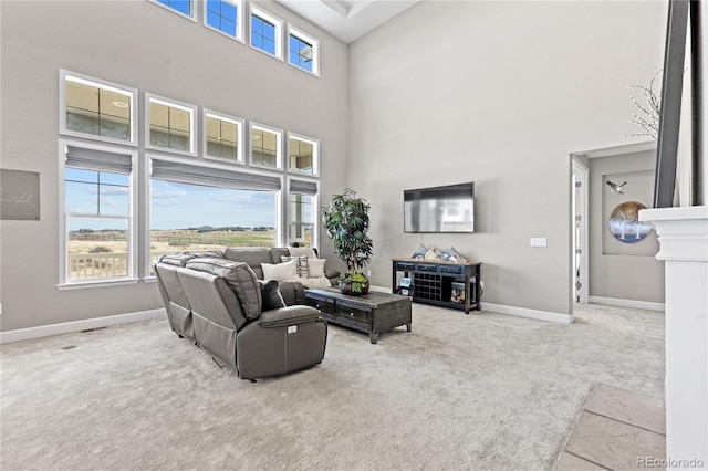 living room featuring light carpet and a towering ceiling