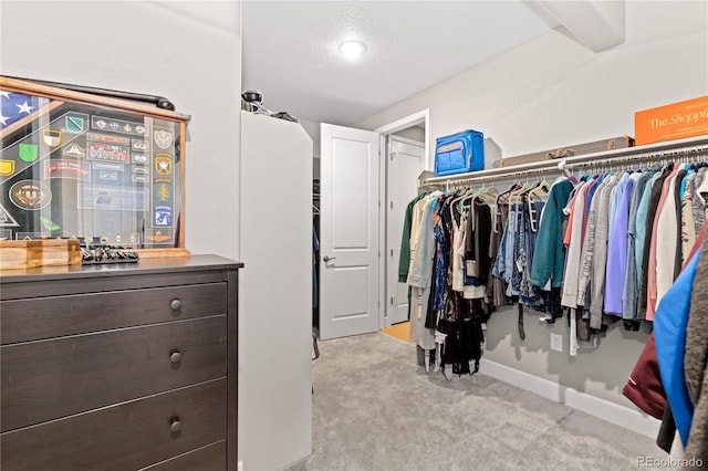 walk in closet with light colored carpet