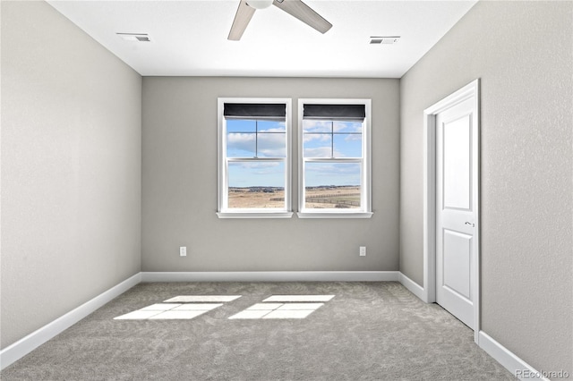 carpeted spare room with ceiling fan