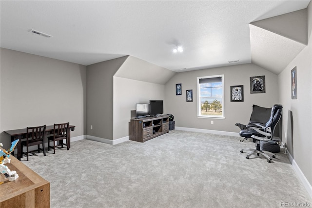 office featuring vaulted ceiling, a textured ceiling, and light carpet