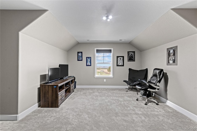 office featuring a textured ceiling, light colored carpet, and vaulted ceiling