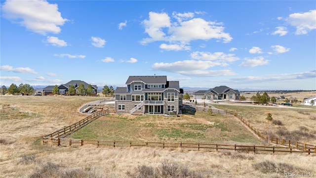 back of house with a rural view