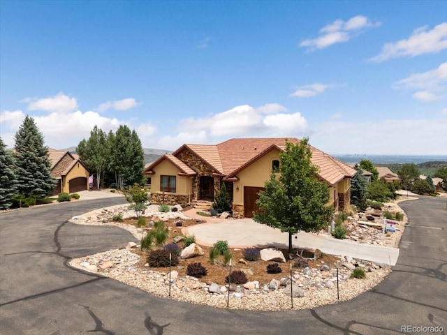 6170 Falcon Ridge Ln, Morrison, CO 80465 - view of front facade featuring stucco siding, a garage, a tile roof, and driveway