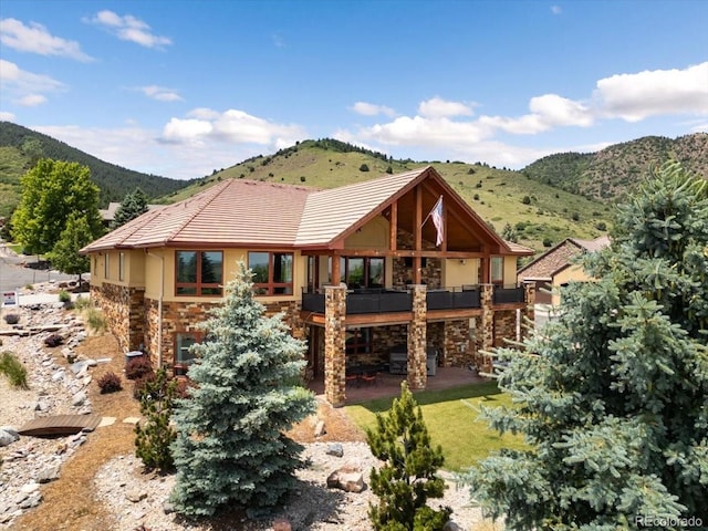 6170 Falcon Ridge Ln, Morrison, CO 80465 - rear view of house featuring stone siding, a tiled roof, a patio, and stucco siding