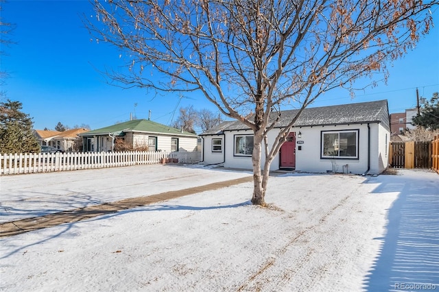 ranch-style house with a fenced front yard and roof with shingles