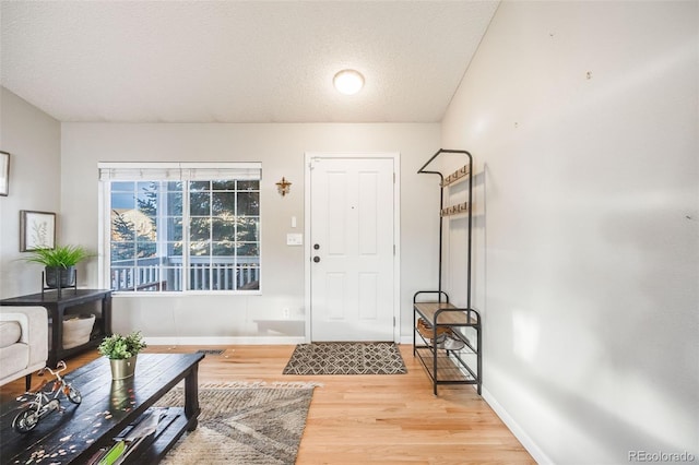 entryway with wood-type flooring and a textured ceiling