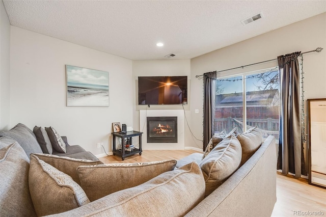 living room with light hardwood / wood-style flooring and a textured ceiling