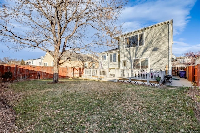 rear view of house with a lawn, a deck, and a patio