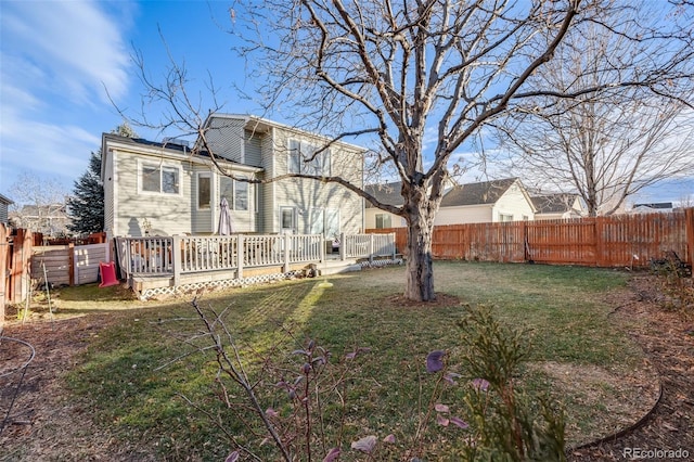 back of property with a lawn and a wooden deck