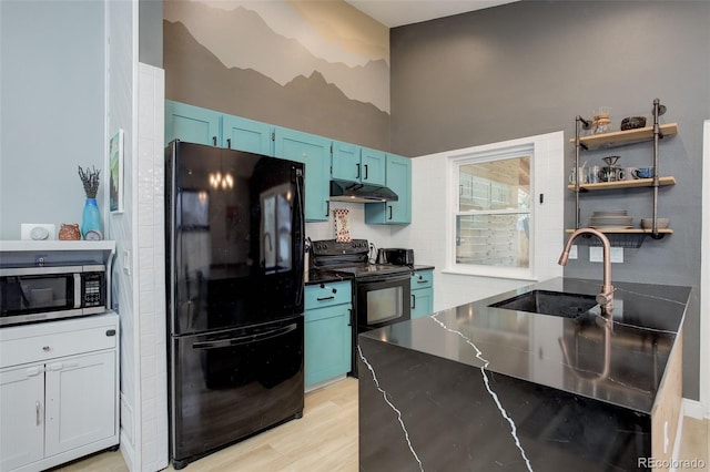 kitchen with black appliances, under cabinet range hood, a sink, blue cabinetry, and open shelves