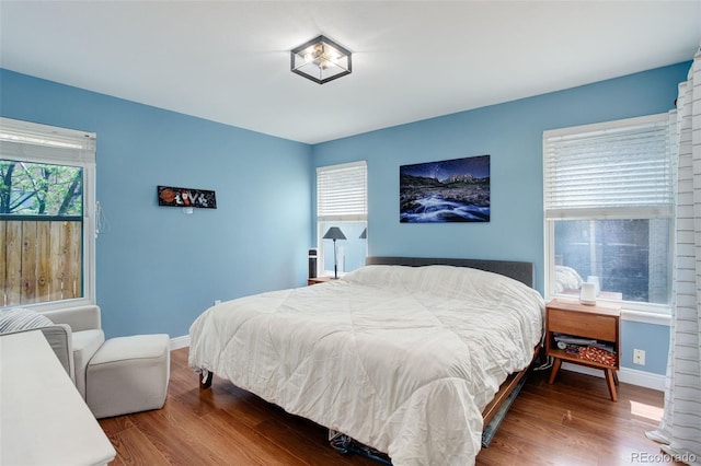 bedroom with baseboards and wood finished floors