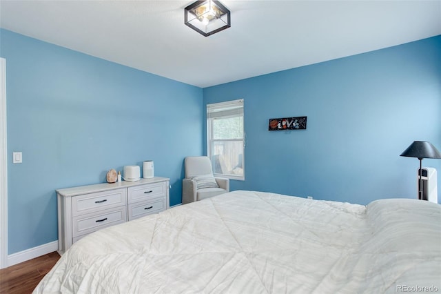bedroom with dark wood-style flooring and baseboards