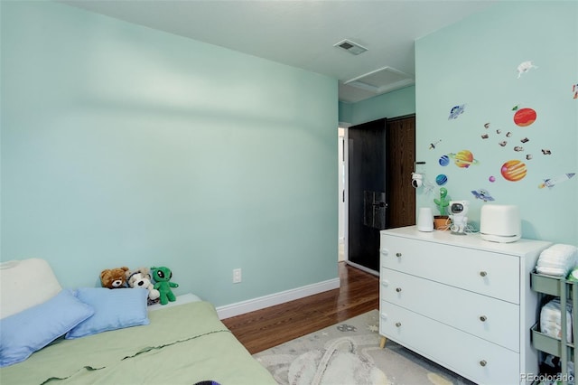 bedroom featuring light wood-style flooring, attic access, and baseboards
