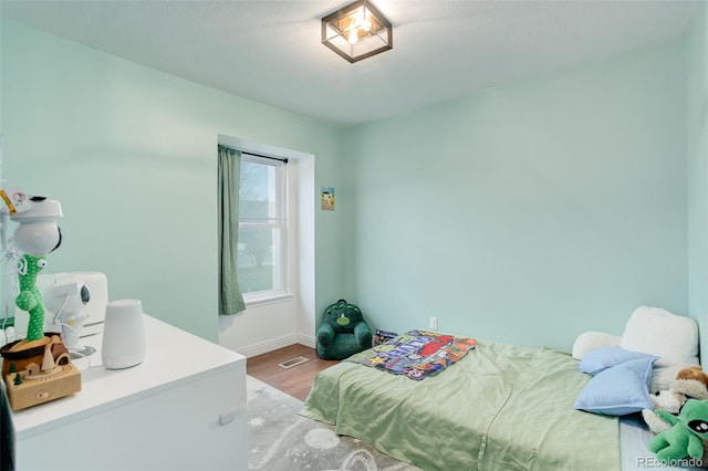 bedroom featuring wood finished floors and baseboards