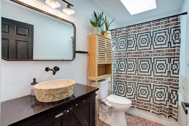full bath featuring a skylight, toilet, and vanity