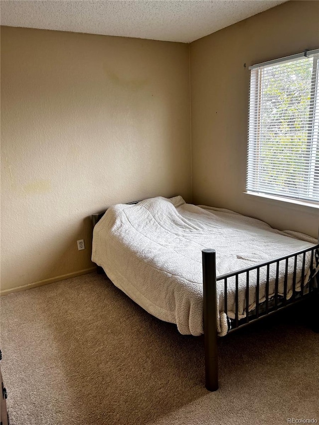 carpeted bedroom featuring a textured ceiling