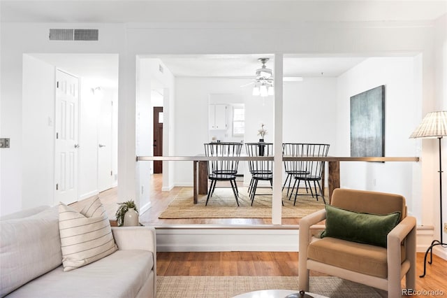 living room featuring ceiling fan, wood finished floors, and visible vents